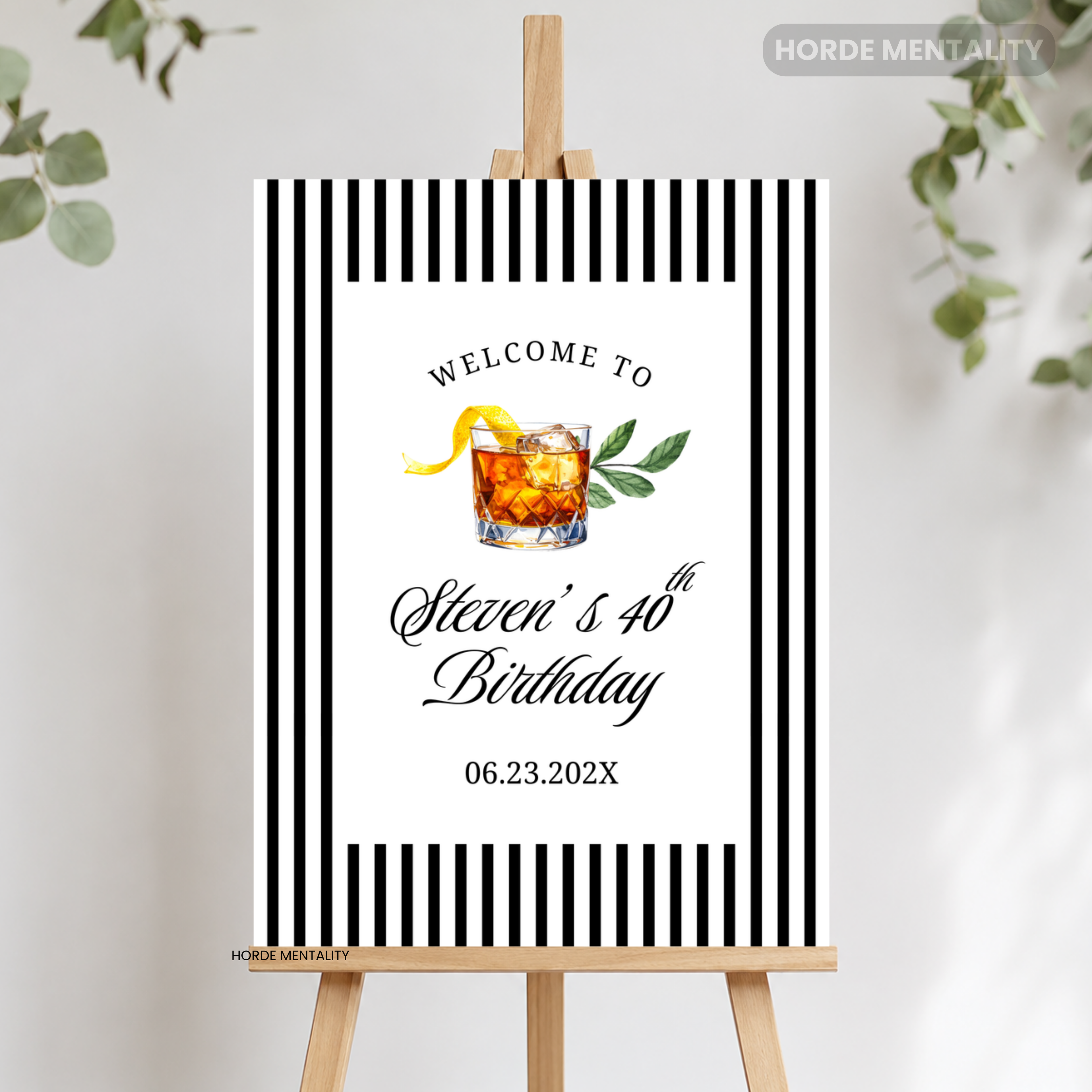 A personalized black and white striped welcome sign on a wooden easel, featuring a cocktail illustration and the text 'Welcome to Steven's 40th Birthday' with a date.