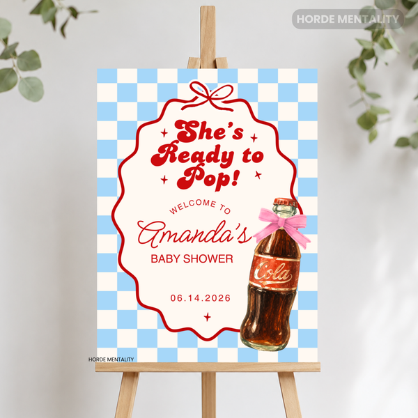 A personalized baby shower sign on a wooden easel, featuring a blue and white checkered border, a red scalloped frame, the text 'She's Ready to Pop! Welcome to Amanda's Baby Shower,' a printed bottle illustration with a pink bow